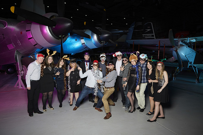 Some of our team dressed outlandishly in an aeroplane hanger