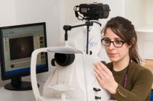 Photo of Emily Wells using a retinal camera